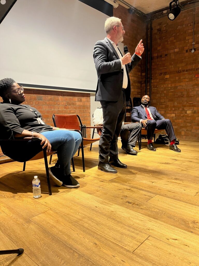 Four panel members including Dr David Kirby (standing) answer questions about knife crime during a screening of our Just Drop It film
